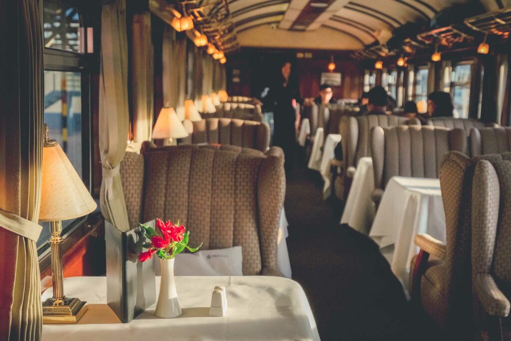 The luxury wooden decoration with comfortable sofas and fancy table lamps of the Perurail Titicaca train