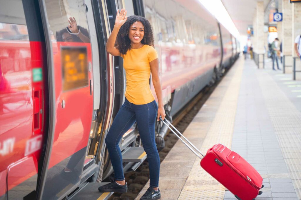 Afro woman ready to take the train waving hand