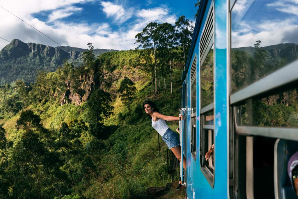 Beautiful girl traveling by train among mountains. The girl travels by train to beautiful places.